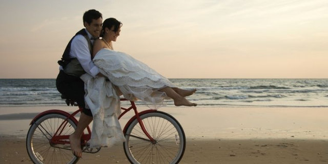Pareja en bici por la playa